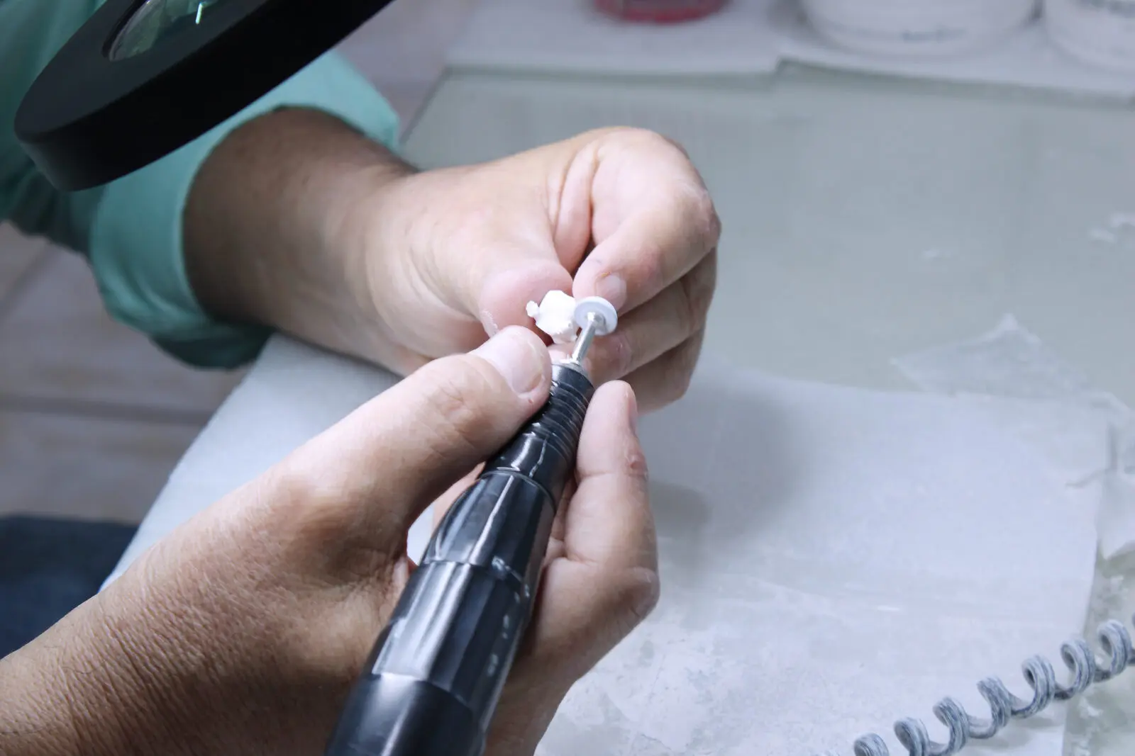 Hand finishing of a dental crown under magnification
