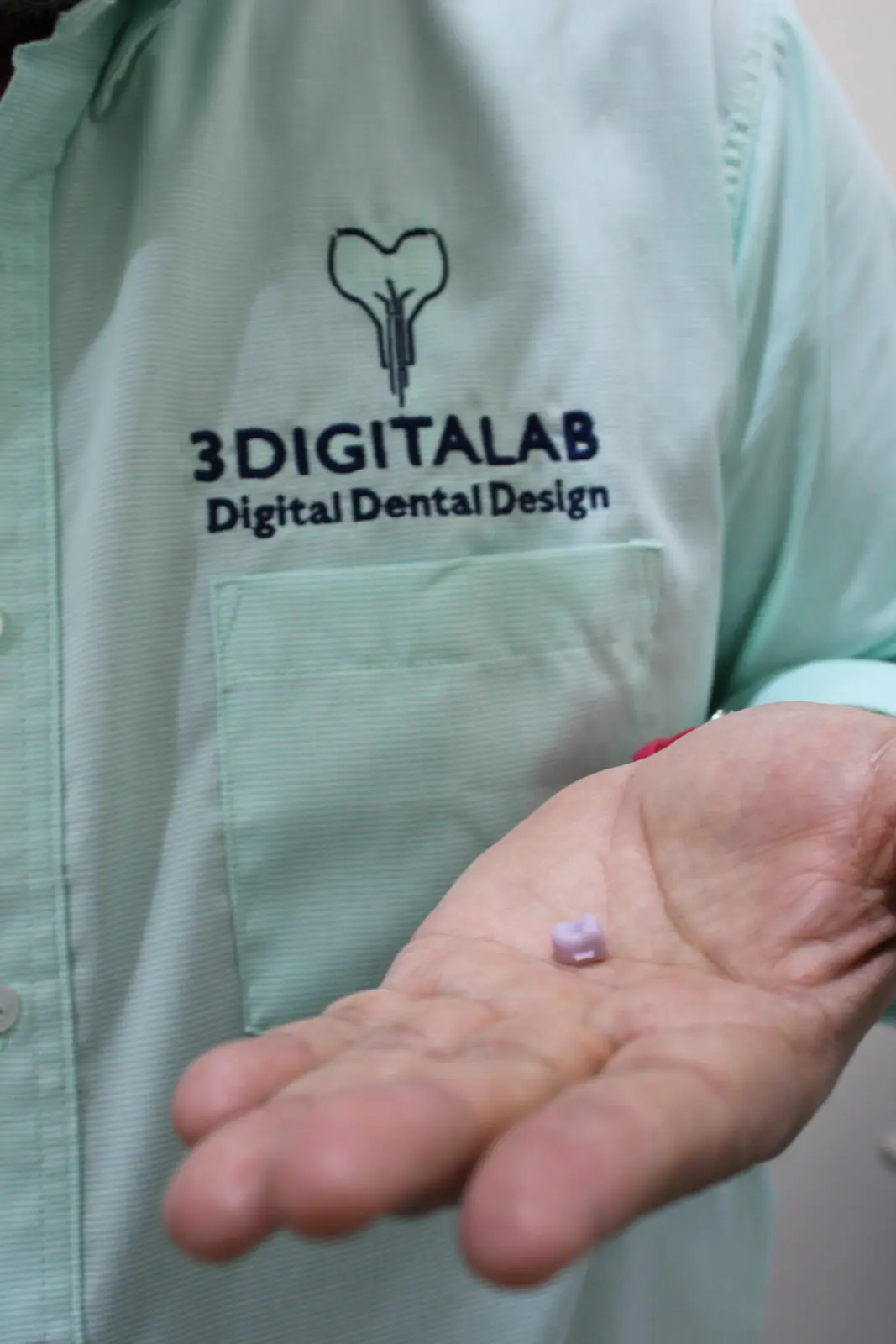 Pre-sintered zirconia crown in the hand of a 3DigitaLab technician