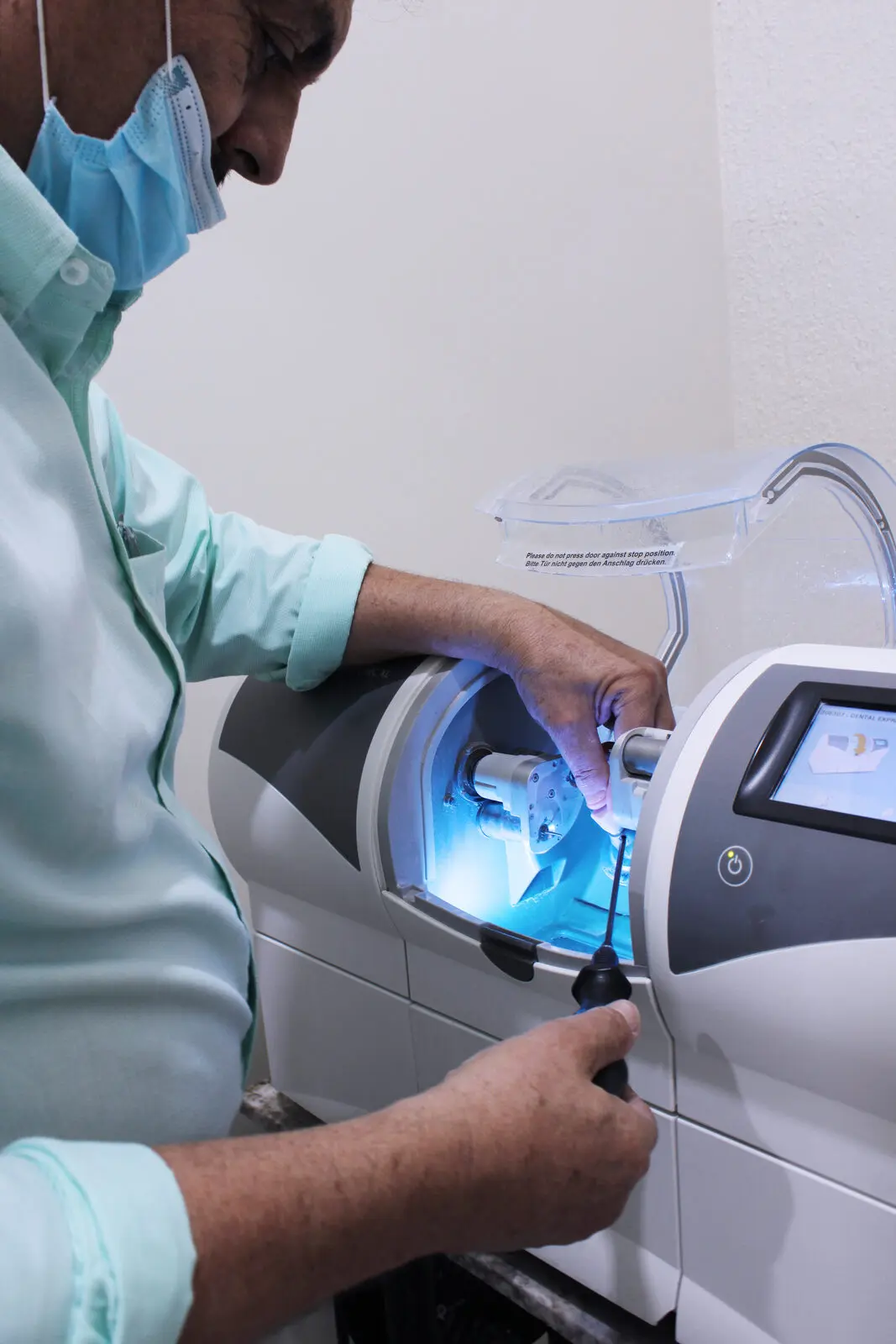 Technician adjusting the dental lab CAD/CAM mill